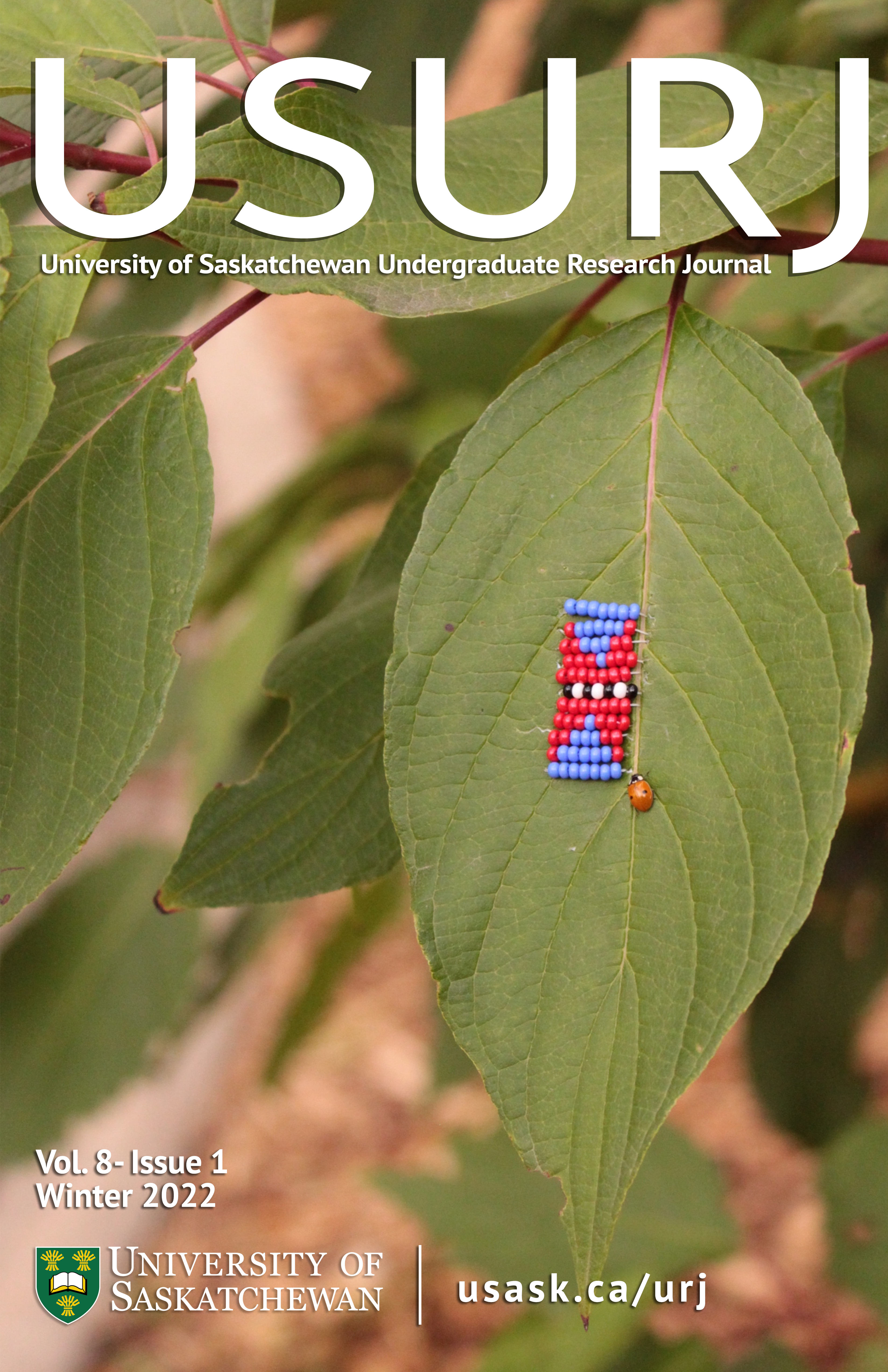 A photograph of red and blue ibeading stitched onto a green leaf with a ladybug crawling next to it.